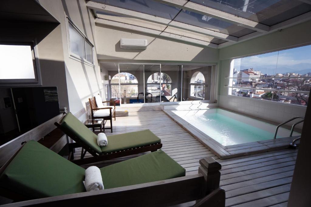 萨尔塔阿尔梅里亚酒店的客房设有游泳池、椅子和大窗户。