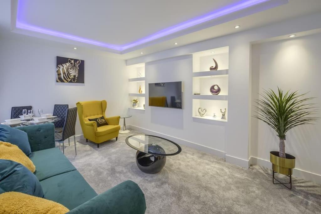 阿伯丁Vion Apartment- Westerton的客厅配有蓝色的沙发和黄色的椅子