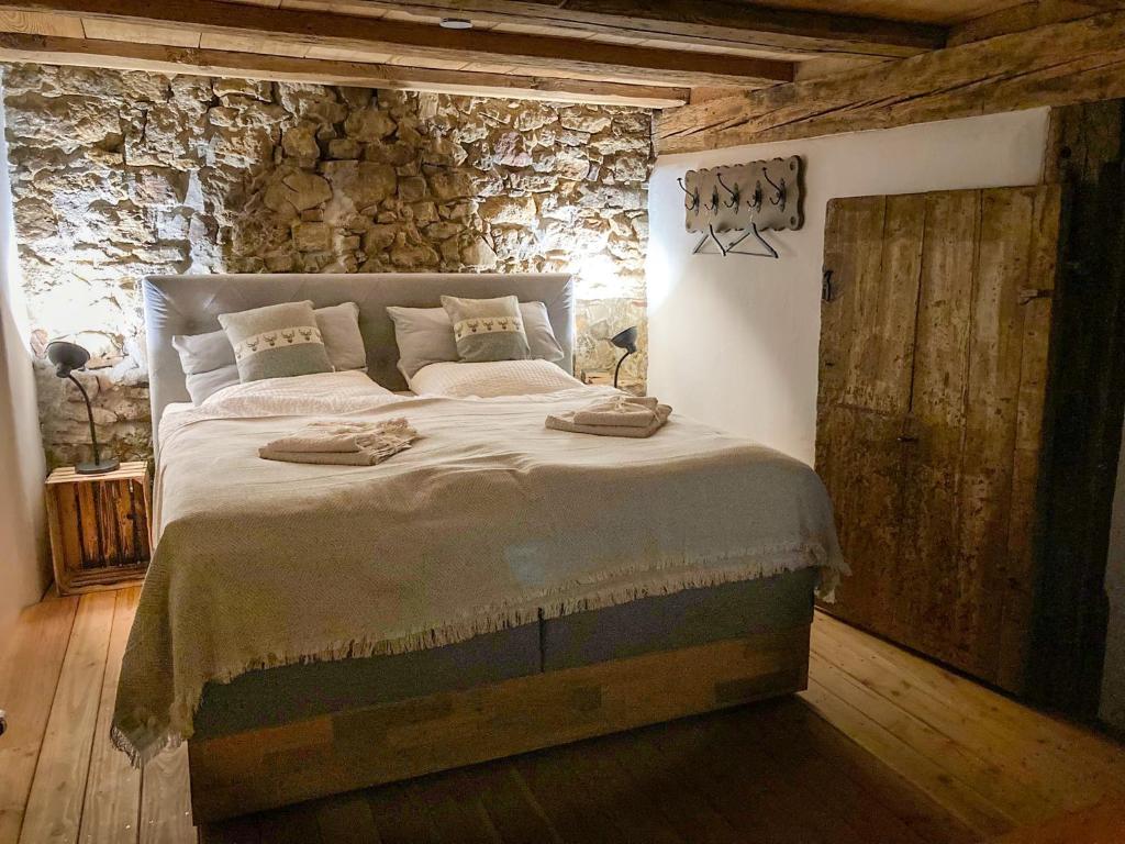 斯图林根PEARLs - Stilvolle Wohnung zwischen dem Schwarzwald & der Schweiz的一间卧室设有一张带石墙的大床