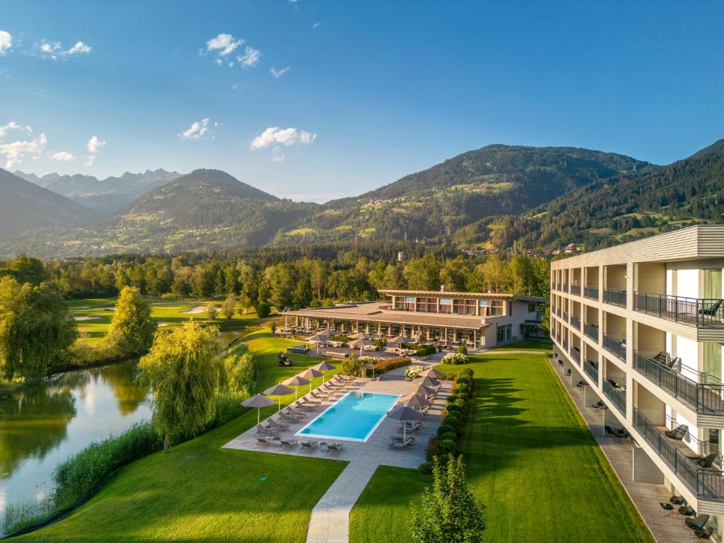 LavantDolomitengolf Suites的享有带游泳池和山脉的度假村的空中景致