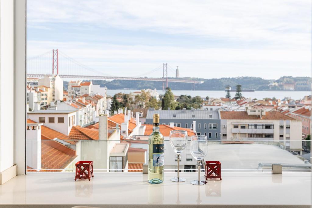 里斯本Tejo River View Apartment nearby Belém的一张桌子上放着一瓶葡萄酒和玻璃杯,享有美景