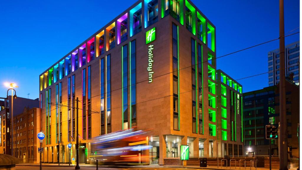 曼彻斯特曼彻斯特城市中心假日酒店的建筑上有着绿色和色彩缤纷的灯光