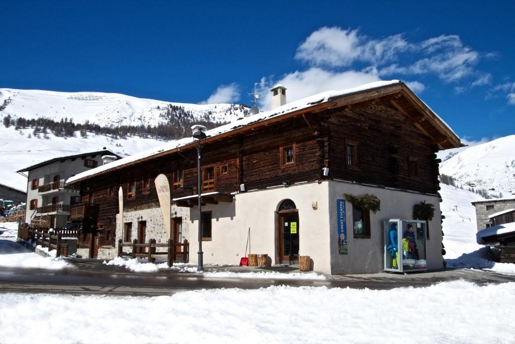 利维尼奥Casa Gallo的雪中木头建筑,有山