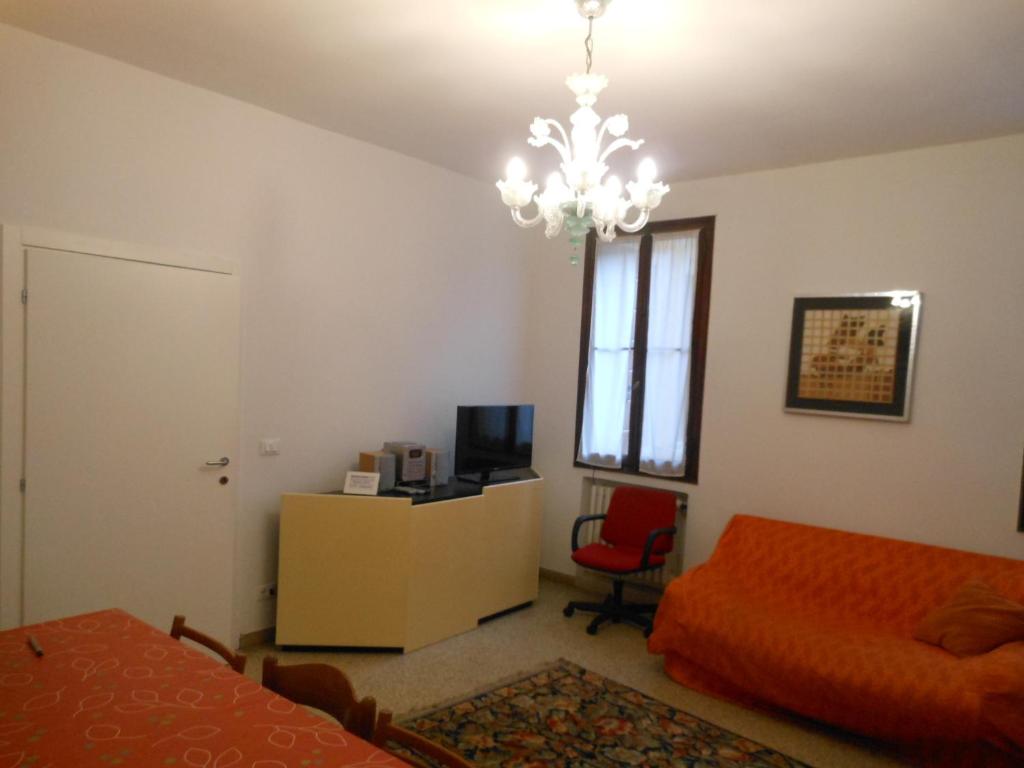 威尼斯多赛公寓的一间卧室配有一张床和一个吊灯