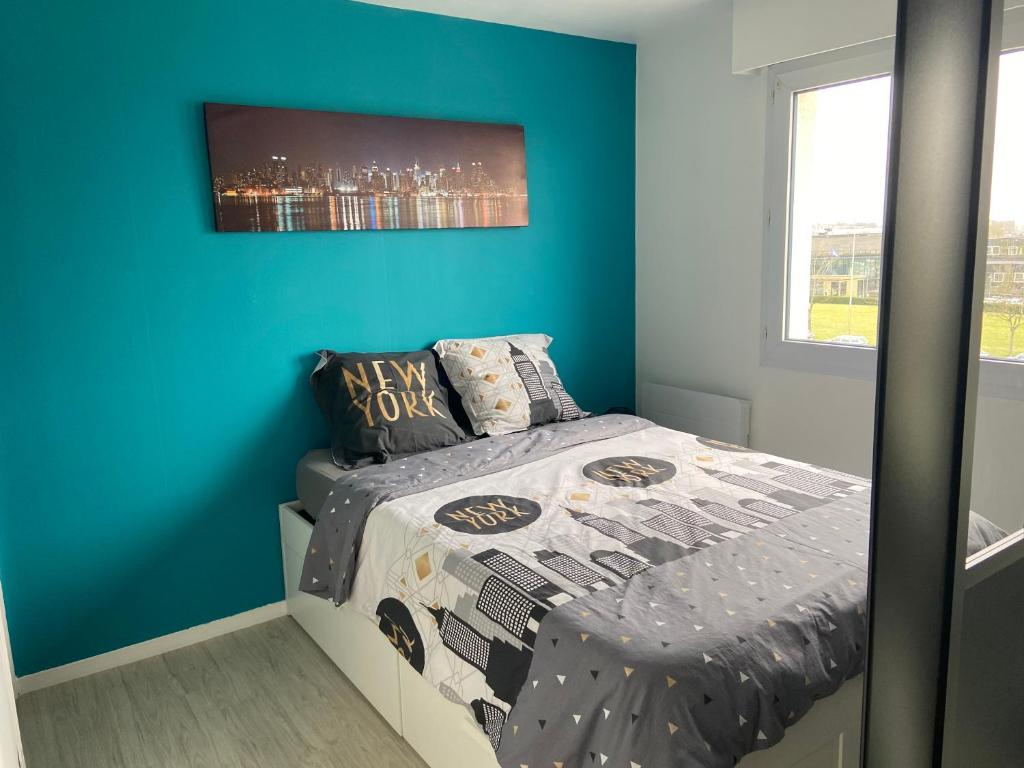 凯恩Grand Studio Lumineux Caen Memorial的一间卧室配有一张蓝色墙壁的床