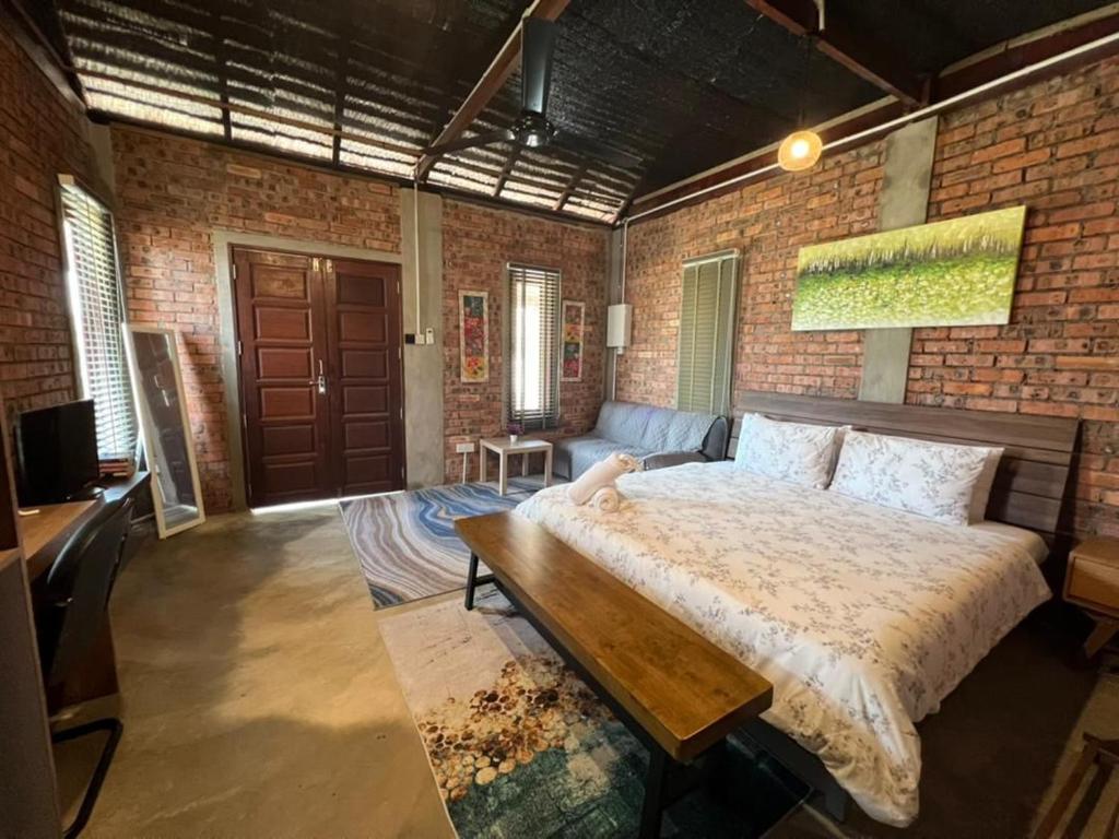 佩纳利克村Rembulan Escape - The Red Bowl的一间卧室设有一张大床和砖墙