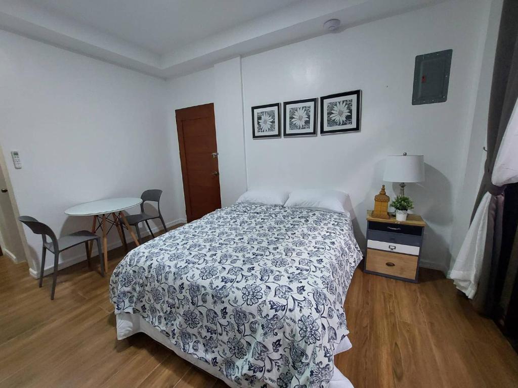 安吉利斯Regal425 Condotel的一间卧室配有一张床和一张桌子及椅子