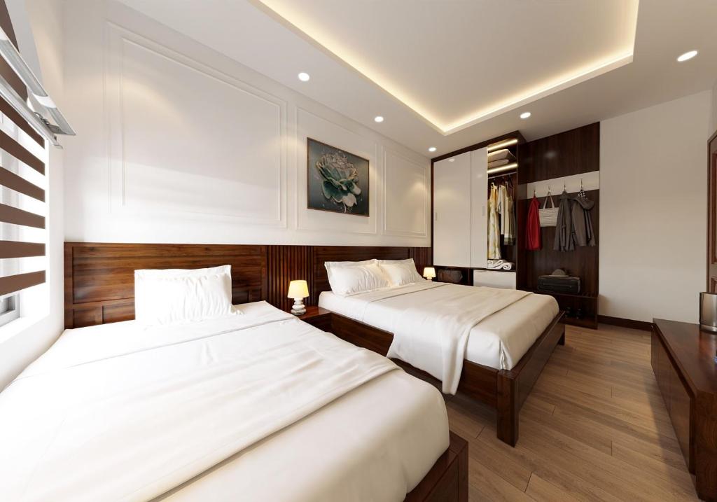 宁平Tamcoc Catalina Hotel的配有白色床单的酒店客房内的两张床