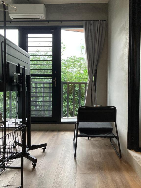 宜兰市薛宅的一间带椅子和电视的客房以及一个阳台