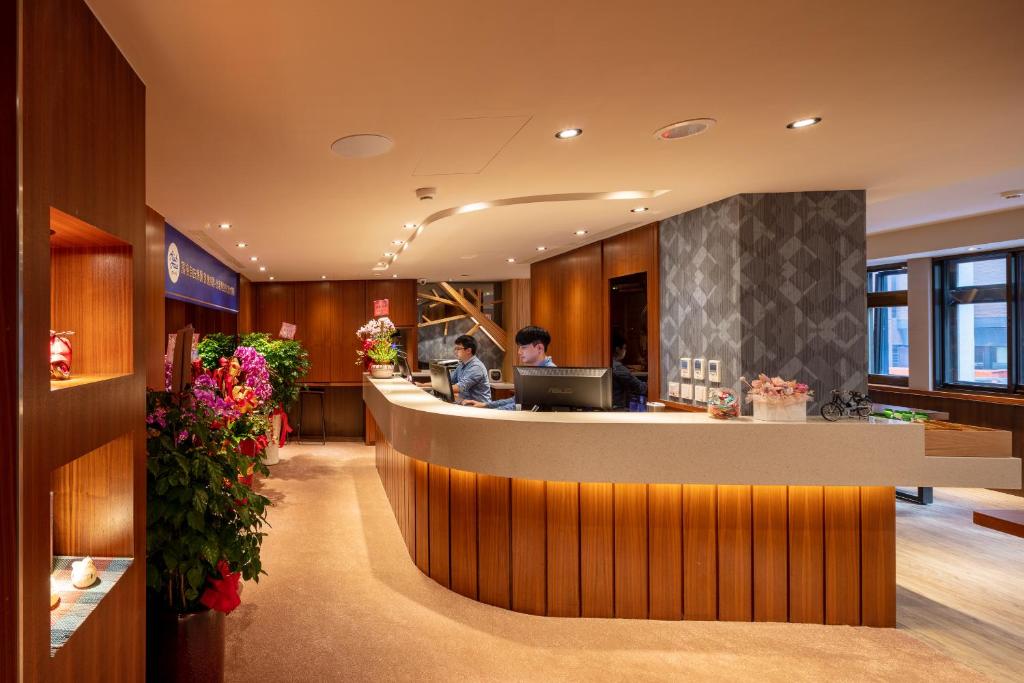 台北Rich & Free Hotel - Kaifeng 富逸旅趣-北車開封館的酒店大堂设有前台柜台和鲜花