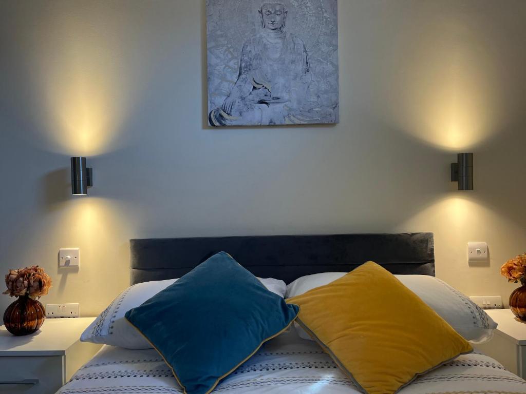 伦敦Pods of Kings Cross -1的卧室里一张带蓝色和黄色枕头的床