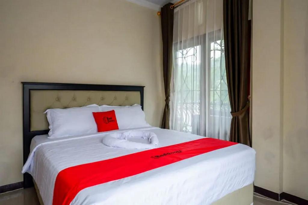 MakaleRedDoorz at Makale Tana Toraja的一间卧室配有一张带红色毛巾的床