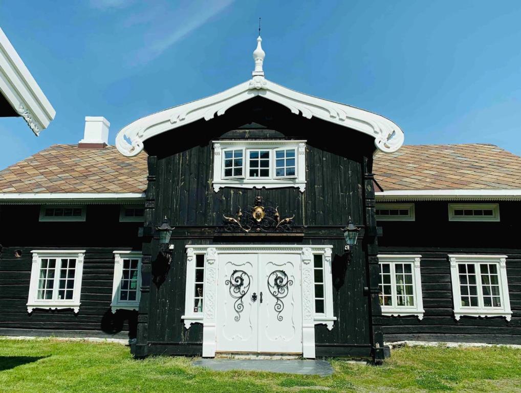 Traditional timber farm with Sauna & Wi-Fi的前面有一扇白色门的黑色房子