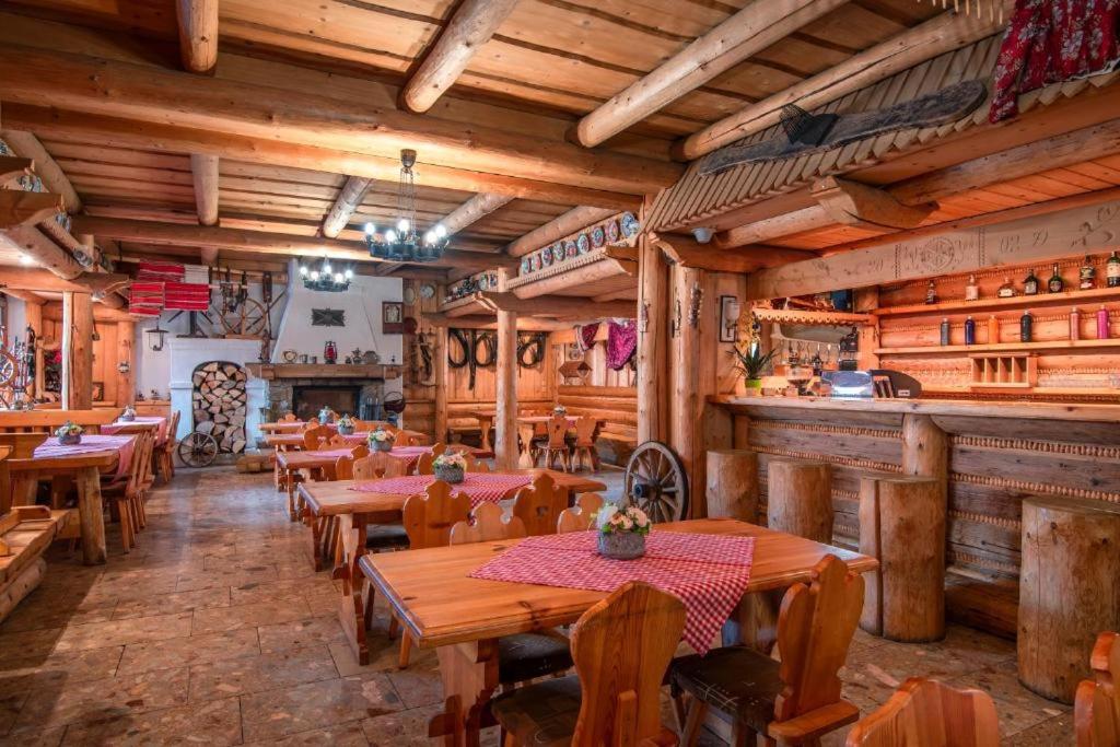 兹蒂尔Turistické ubytovanie Sova的一间带木桌椅的餐厅和一间酒吧