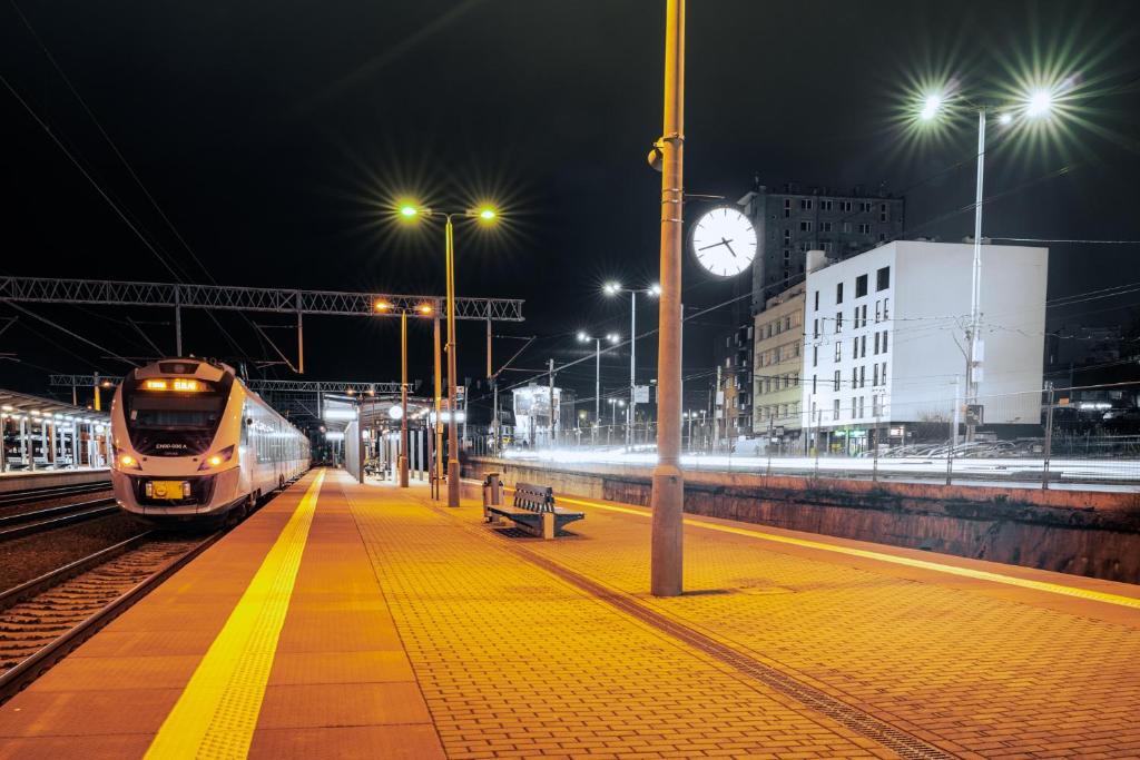 格丁尼亚Apartamenty Przystanek Morska的火车在晚上开进火车站