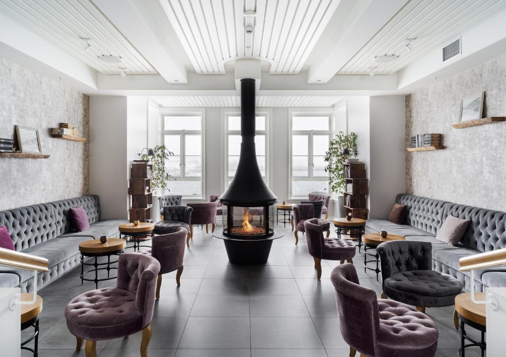 锡格吕菲厄泽Siglo Hotel by Keahotels的一间带壁炉、椅子和桌子的餐厅