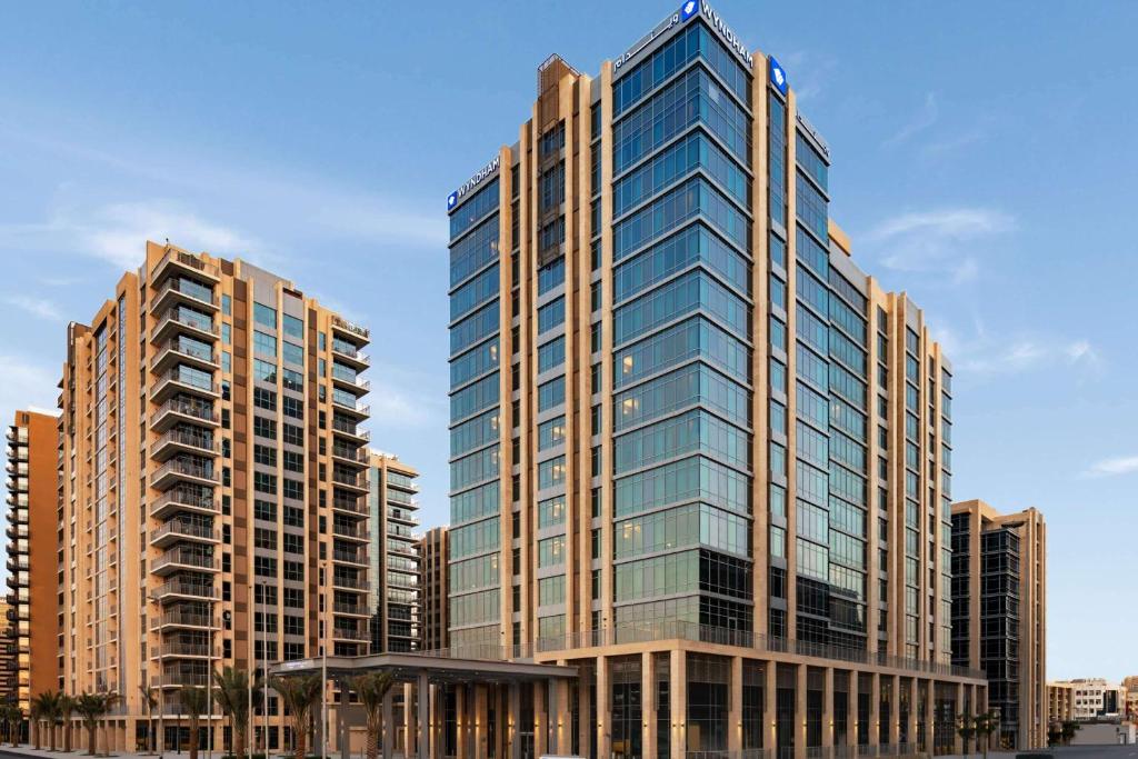 迪拜Wyndham Dubai Deira的一座高大的建筑,在城市里装有玻璃窗