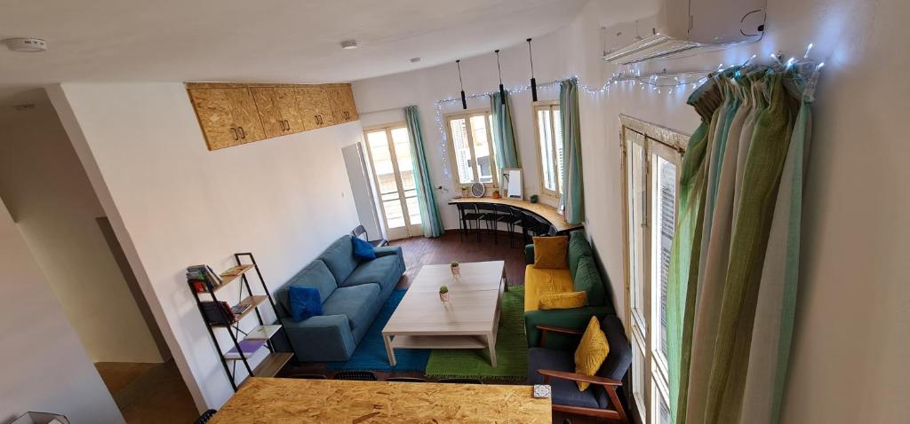 帕福斯Bee Hostel Paphos的客厅配有蓝色的沙发和桌子