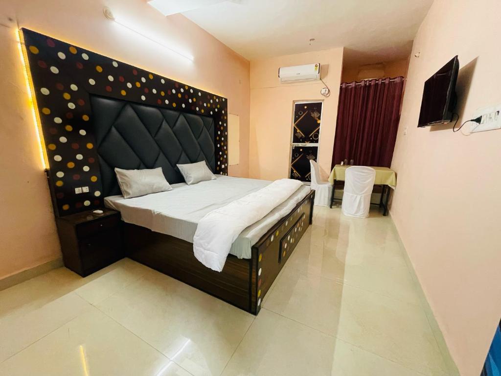 贾巴尔普尔Hotel green park的一间卧室配有一张大床和大床头板
