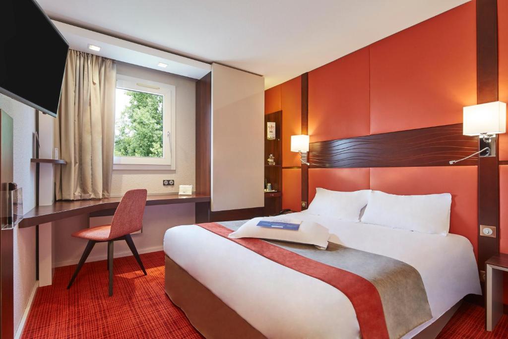 Bouaye爱埃伯特 - 基里亚德酒店的酒店客房设有一张大床和一张书桌。