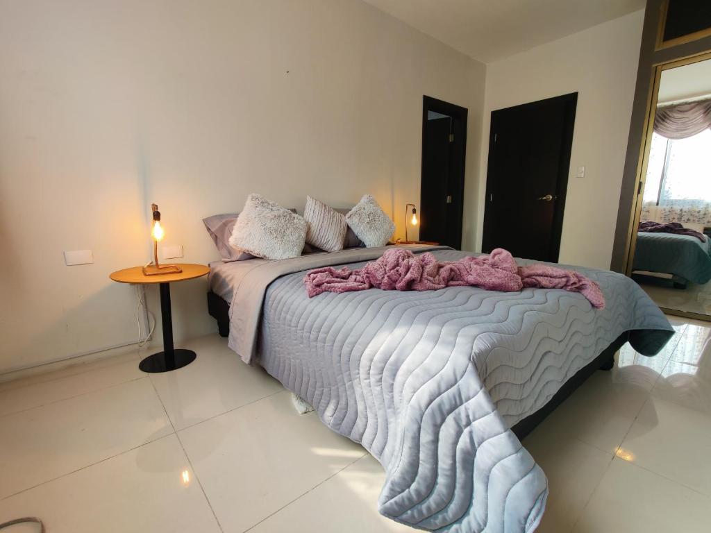 瓜亚基尔Lola's House Guayaquil Self Check-In & B&B的一间卧室配有一张床和一张带台灯的桌子