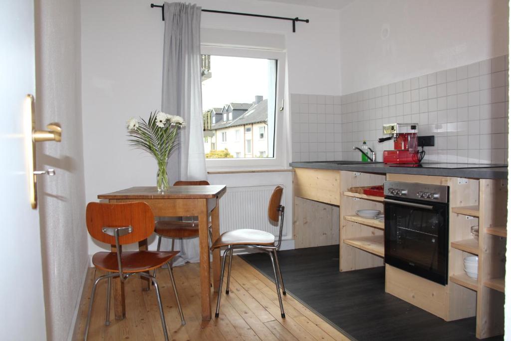 波鸿Apartment Wostspitze的厨房配有桌椅和窗户。