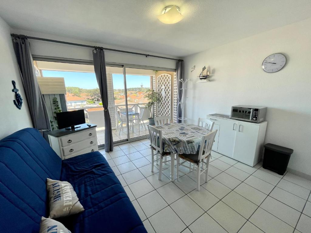 米尼赞海滩Le Surf的客厅配有蓝色的沙发和桌子