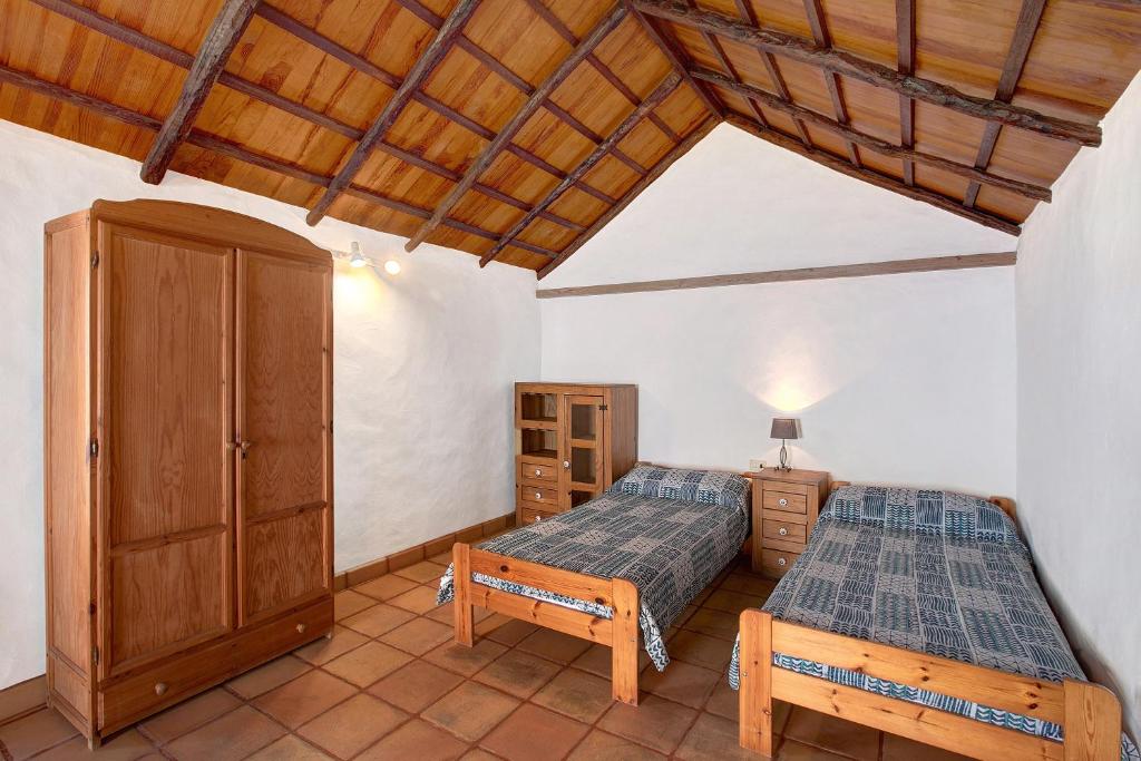 巴尔韦尔德Las Adelfas的一间卧室设有两张床和木制天花板