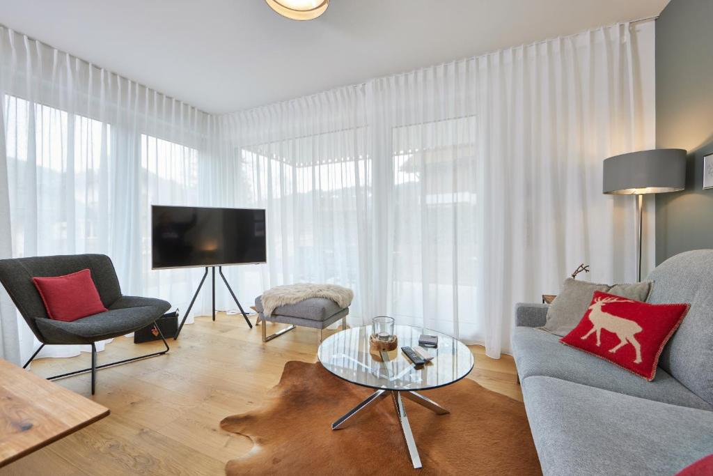 加尔米施-帕滕基兴BergZeit的客厅配有沙发、椅子和电视