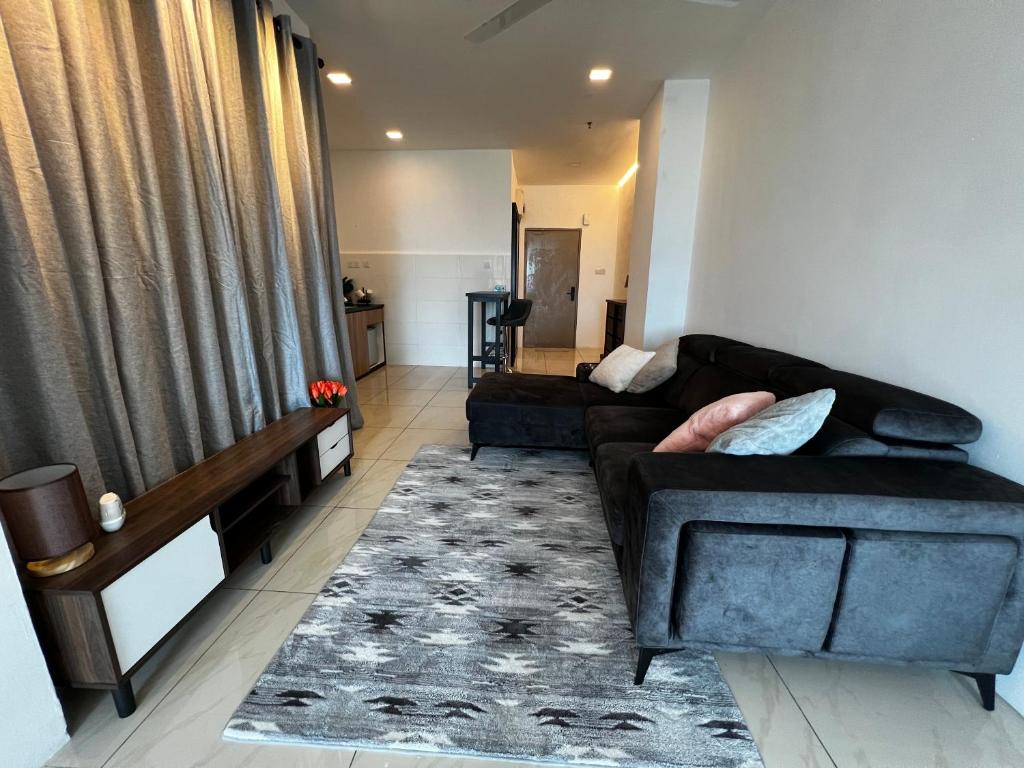 宾南邦ITCC Manhattan Suites by PRIME的客厅配有黑色沙发和地毯。