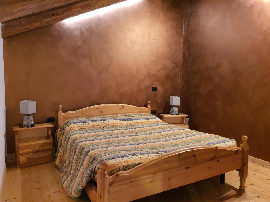 苏萨Agriturismo al pra di muriet的一间卧室配有木床和2个床头柜