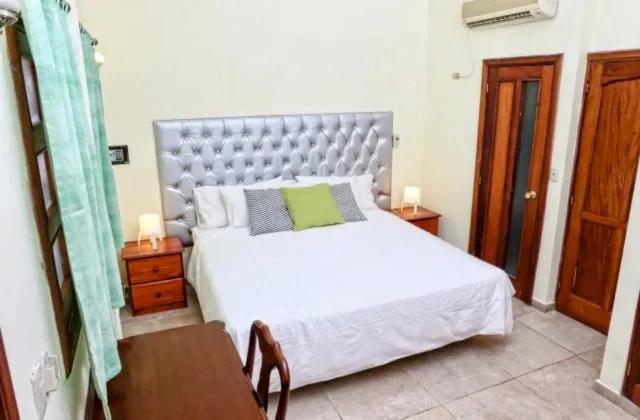 圣多明各Hotel Aluge的卧室配有一张白色的大床和一张桌子