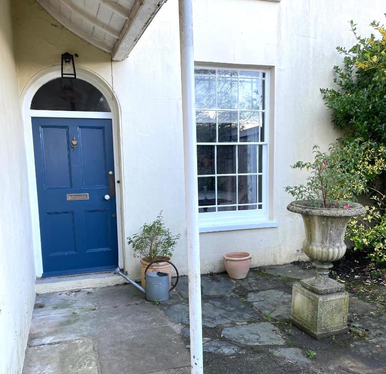 托特尼斯Luxury flat in Totnes的两棵盆栽植物的房子的蓝色门