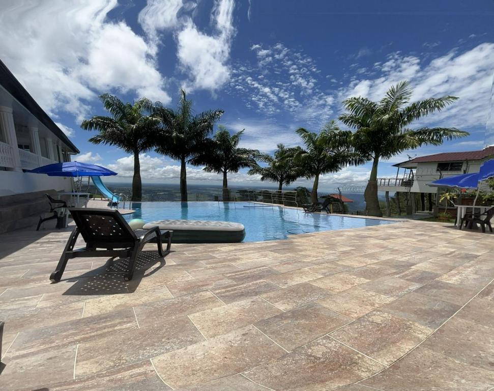 比亚维森西奥Mirador El paraiso glamping的一个带长凳和棕榈树的游泳池