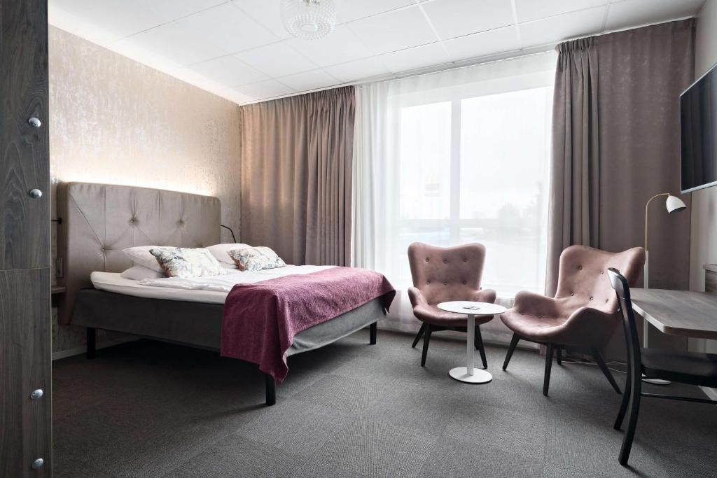 永比永比贝斯特韦斯特酒店的一间卧室配有一张床、两把椅子和一张桌子