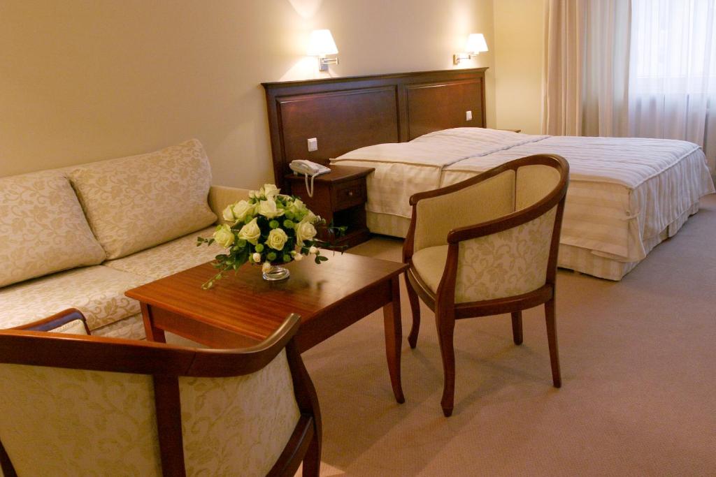热舒夫普莱斯登奇三星级酒店的酒店客房配有床、沙发和桌子。
