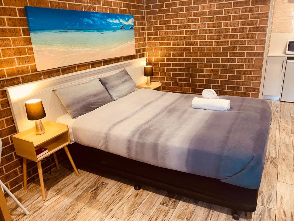安特兰斯Buccaneer Motel的一间卧室设有一张床和砖墙