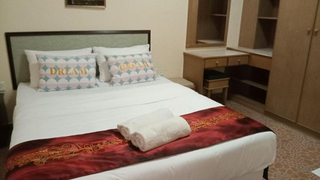 卢穆特Apartment Teluk Batik的卧室配有白色的床和毛巾