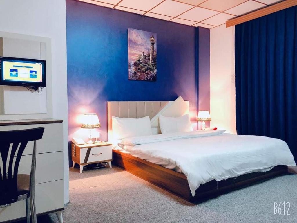 埃尔比勒Hotel Sinaia Palace的一间卧室配有一张大床和电视