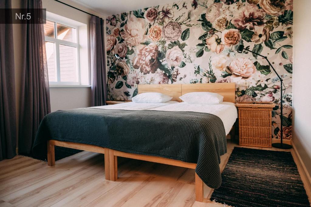 MilzkalneKalndaķi的一间卧室配有一张带花卉壁纸的床