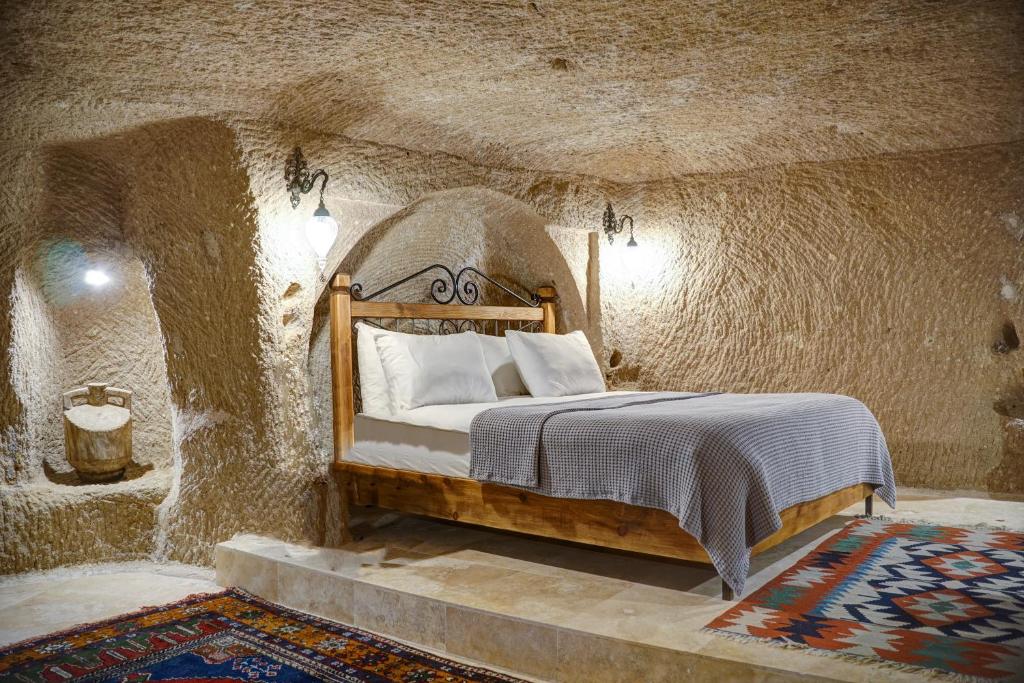 乌奇希萨尔Karma Suites Cappadocia的卧室配有一张石墙床