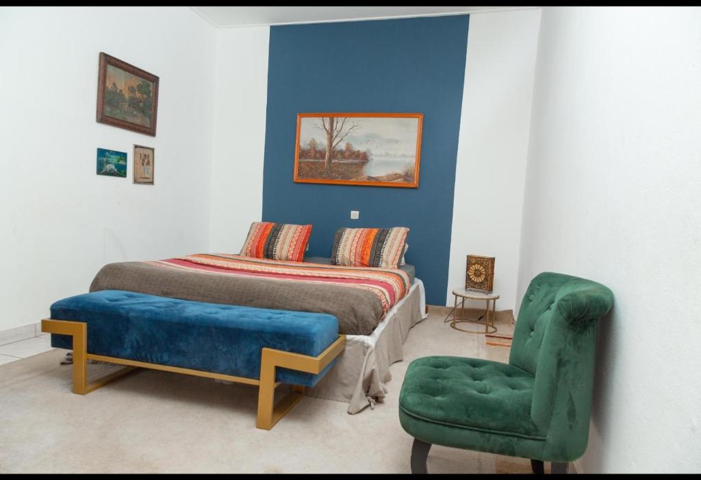 雅温得DUPLEXE HAUT STANDING centre ville Quartier Fouda的一间卧室配有一张床和一把绿色椅子