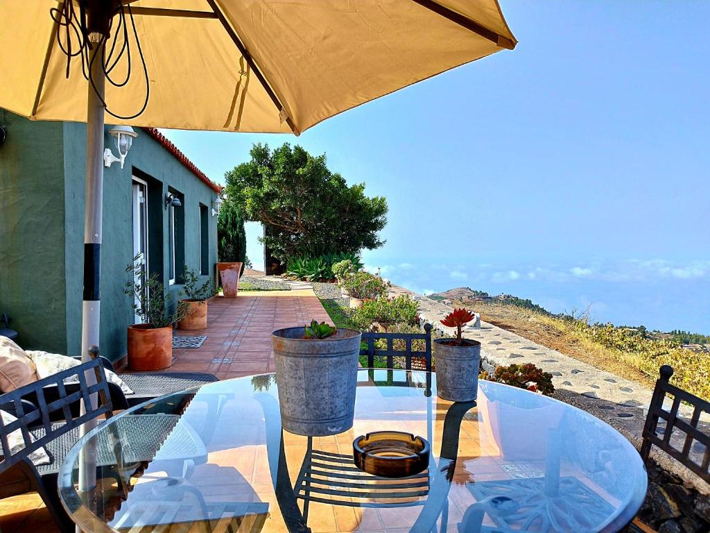 蓬塔戈尔达El Topo的露台上的玻璃桌和遮阳伞