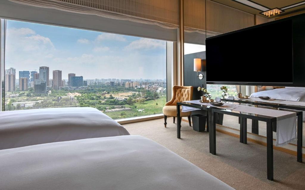 古尔冈Grand Hyatt Gurgaon的酒店客房设有两张床和大窗户。