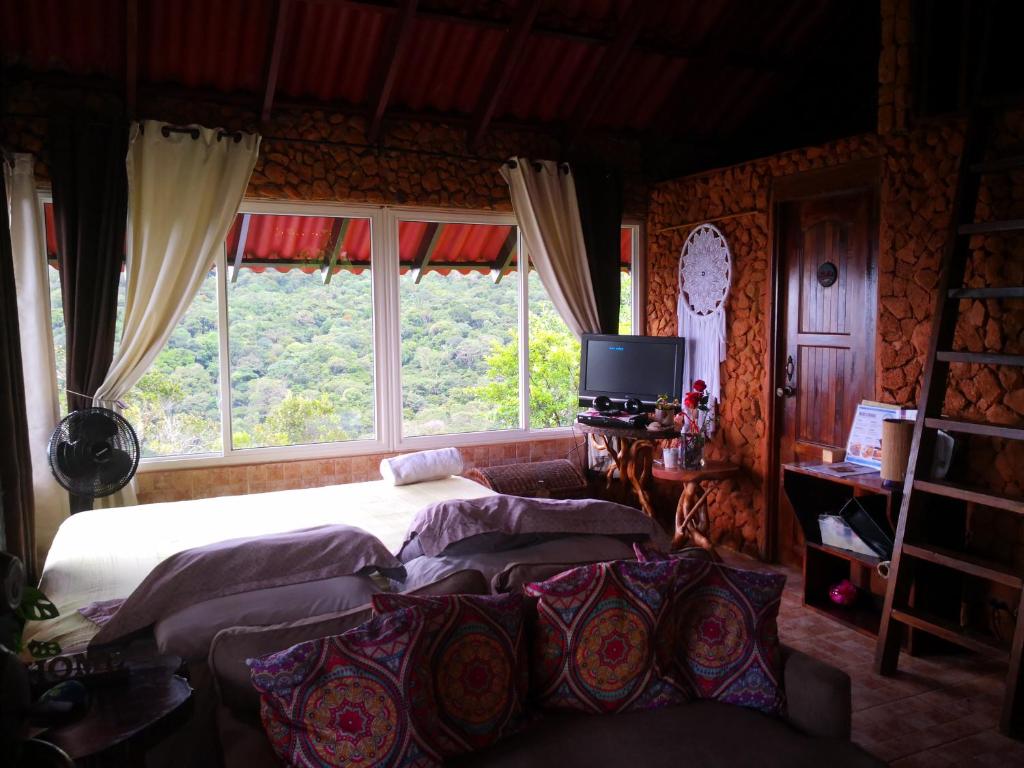 塞罗阿苏尔Mandalas Ecolodge的一间卧室设有两张床和大窗户