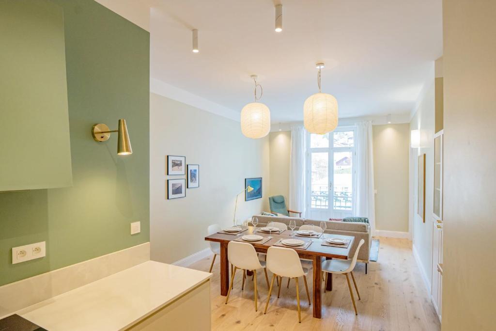 夏蒙尼-勃朗峰Majestic Alpin - A luxurious apartment with a nordic feel的厨房以及带桌椅的用餐室。