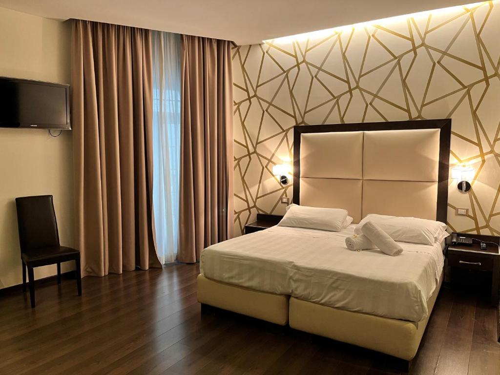 罗马Catone District Hotel的一间卧室配有一张大床和电视