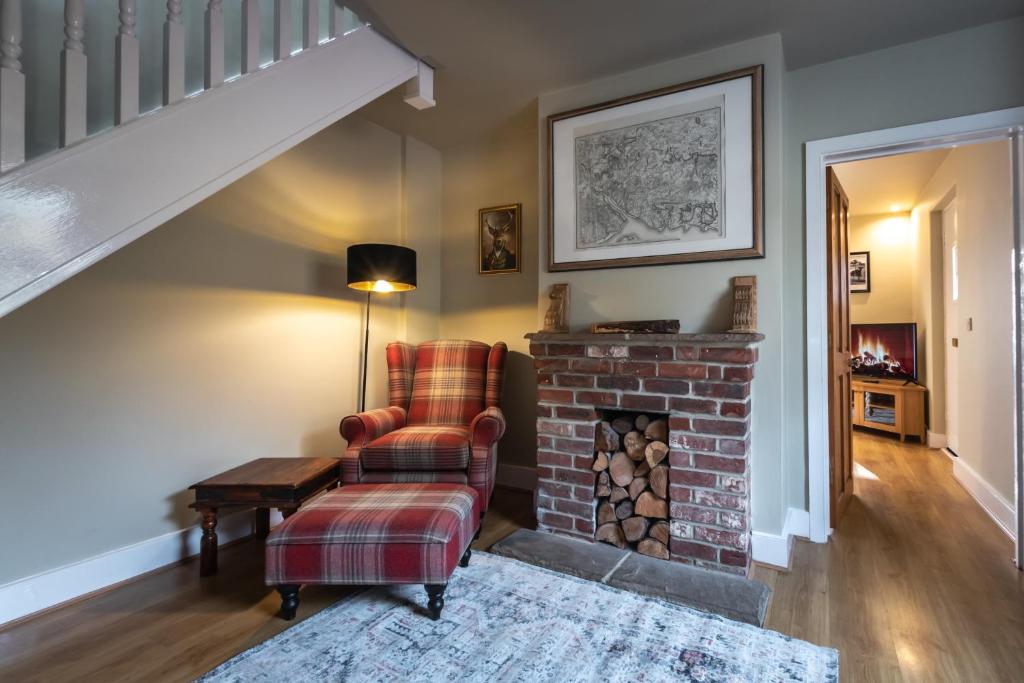 南安普敦Rustic cabin located in a serene forest setting的客厅配有椅子和砖砌壁炉