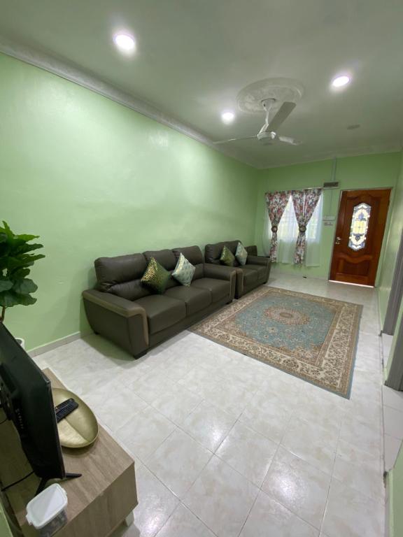 马日丹那Green Home Homestay Melaka的带沙发和地毯的客厅