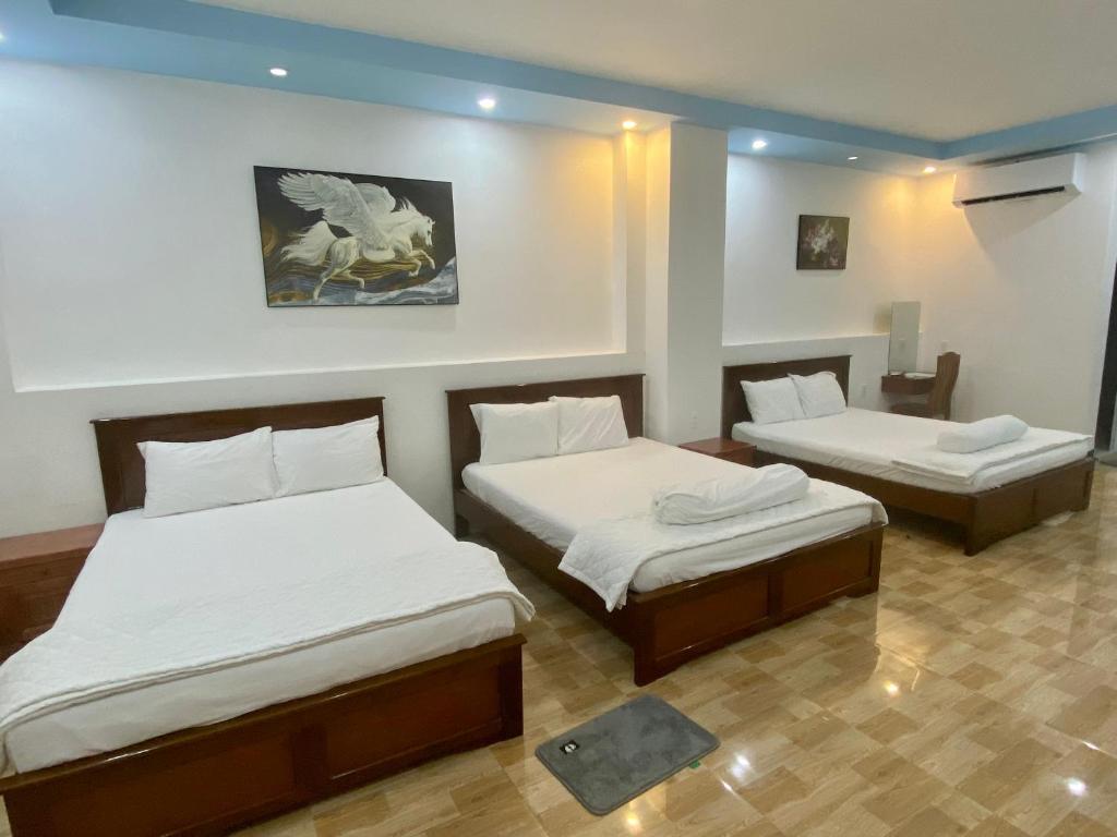 Bạc LiêuKhách sạn Anh Tuấn的一间客房内配有两张床的房间